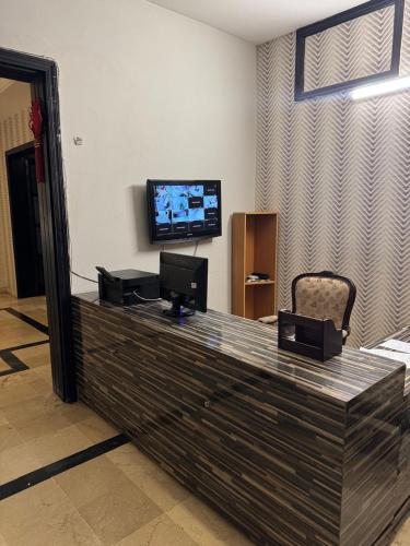a living room with a counter with a television and a chair at Arizona Lodge 2 in Islamabad