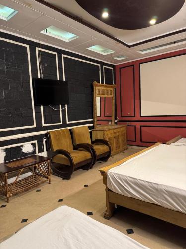 a room with two beds and a flat screen tv at Arizona Lodge 2 in Islamabad