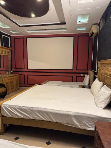 a large bed in a room with a large screen at Arizona Lodge 2 in Islamabad