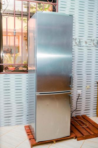 a stainless steel refrigerator sitting in a kitchen at Avek Home Stay Ngorongoro Room in Uru