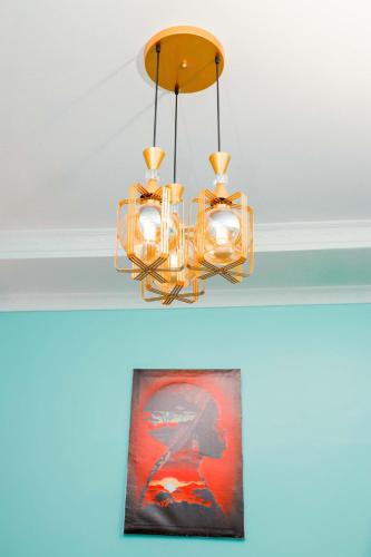 a chandelier hanging from a ceiling with a picture at Avek Home Stay Ngorongoro Room in Uru