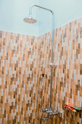 a bathroom with a shower with brown and white tiles at Avek Home Stay Ngorongoro Room in Uru
