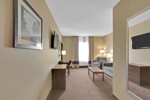 a hotel room with a living room at Duvernay Inn & Suites in Fox Creek