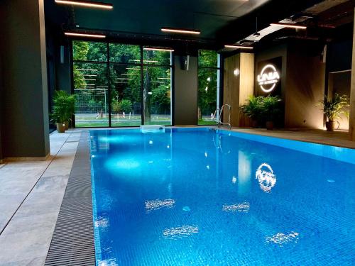 a large blue swimming pool in a building at EASY RENT Apartments - Unia Art Residence 127, Basen & SPA, Centrum 24h Check-in in Lublin