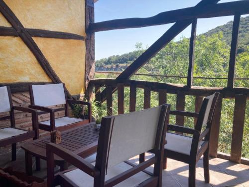 a porch with two chairs and a table with a view at BIDEARTEAN, Caserío vasco, Recién reformado in Záitegui