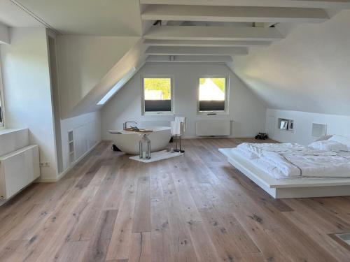 a white bedroom with a bed and a bath tub at Bullerbyn, meets modern luxury in Mörrum