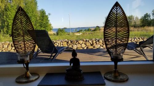 a window with a view of a chair and a bird sculpture at Bullerbyn, meets modern luxury in Mörrum