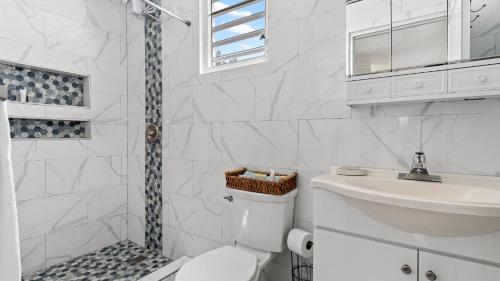 a bathroom with a shower and a toilet and a sink at Unit facing Steps Beach and with close beach access in Rincon