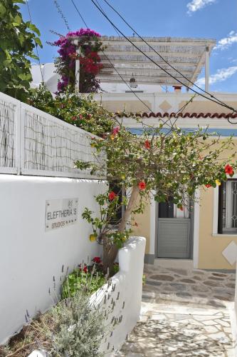 a white house with flowers on the wall at Eleftheria Veloudiou in Tinos Town