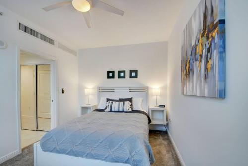a white bedroom with a bed and a ceiling fan at One Bedroom In Amazing Condobeach Pass Included! in Boynton Beach