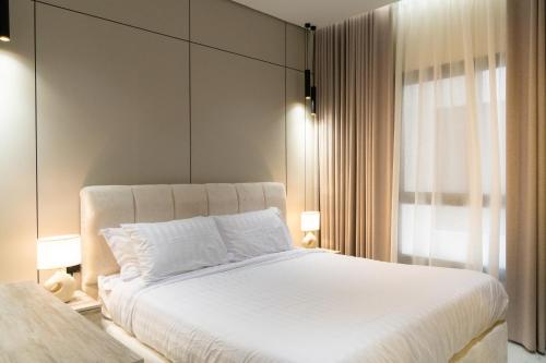 a bedroom with a large white bed and a window at Söz suites in Al Khobar