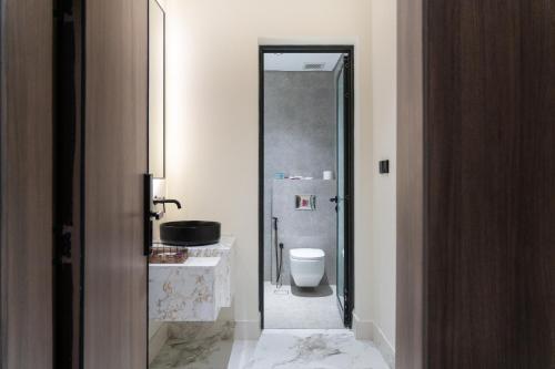 a bathroom with a toilet and a sink at Söz suites in Al Khobar