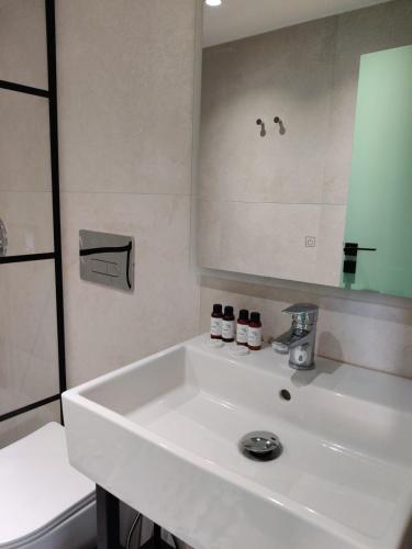 un lavandino bianco in un bagno con uno specchio di Stylish Duplex for 6, Central a Sarandë