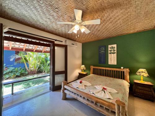 una camera da letto con un letto e un ventilatore a soffitto di Villa das cores a Porto Seguro