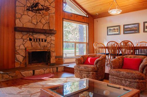 a living room with a stone fireplace and two chairs at Golf Home 010 in Black Butte Ranch