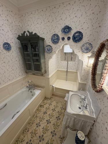 a bathroom with a bath tub and a sink and a bath tub at Meesden Hall in Meesden