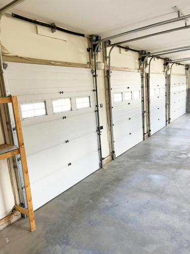 a row of white garage doors in a building at A Gorgeous Mansion for Jasper Vacation in Hinton
