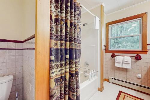 ein Bad mit einem Duschvorhang und einem WC in der Unterkunft North Hill Cross Retreat in Ludlow