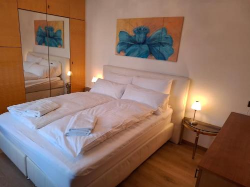 - un grand lit blanc dans une chambre avec deux lampes dans l'établissement Haabsburg Appartment Vienna 6 Personen, Balkon, voll ausgestattete Küche, Grün-Ruhelage am Stadtrand, gute Öffi Anbindung, à Vienne