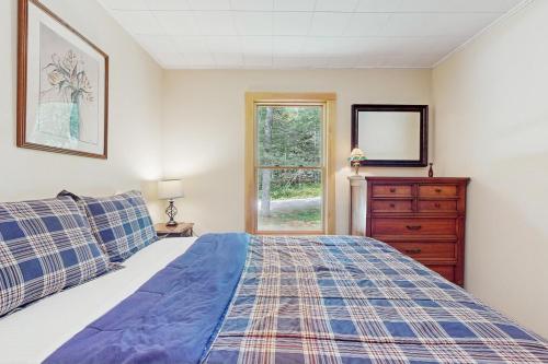 ein Schlafzimmer mit einem Bett, einer Kommode und einem Fenster in der Unterkunft North Hill Cross Retreat in Ludlow
