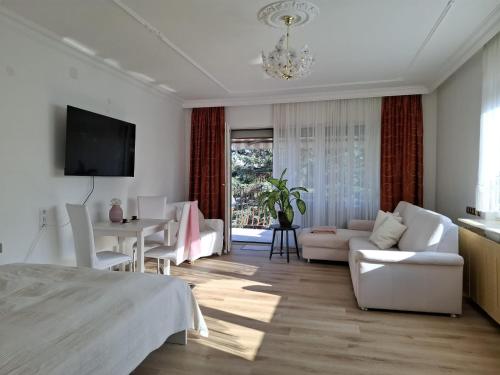un salon blanc avec un canapé et une table dans l'établissement Haabsburg Appartment Vienna 6 Personen, Balkon, voll ausgestattete Küche, Grün-Ruhelage am Stadtrand, gute Öffi Anbindung, à Vienne