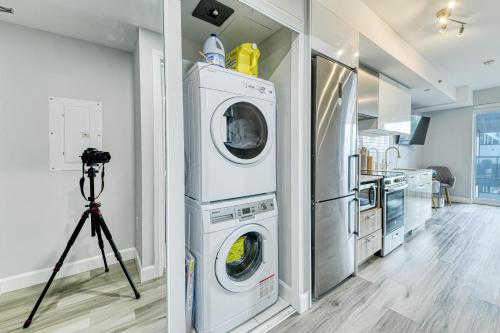 a camera on a tripod in a kitchen with a washing machine at RivetStays - The Jarvis in Toronto