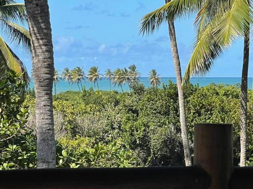 a view of the ocean from a resort with palm trees at Casa Barra do Camaratuba in Mataraca
