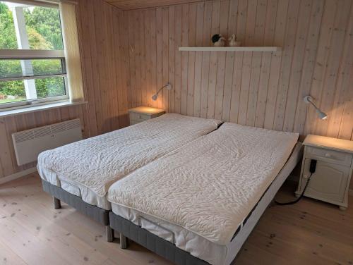 - une chambre avec un lit et deux lampes sur deux tables dans l'établissement Charming Cottage With Large Fenced Garden, à Løgstør