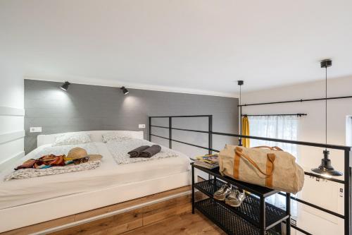 a bedroom with a large white bed with a black frame at Funhouse Dob in Budapest