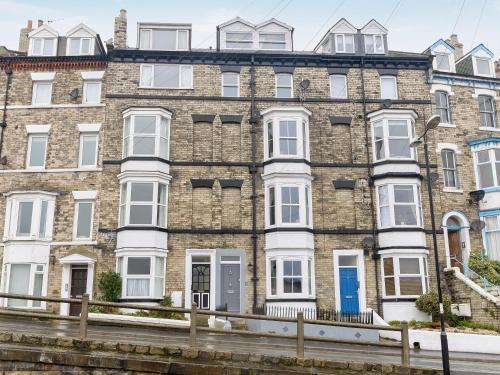 a large brick building with white windows and blue doors at Frankland House in Whitby