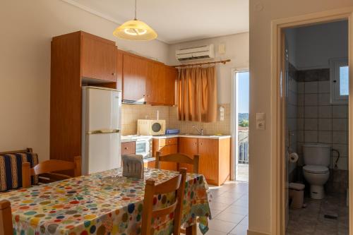 a kitchen with a table and a white refrigerator at Apartments Thekla in Karavádhos