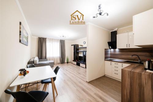 a kitchen and living room with a table and chairs at Центр міста! Затишні квартири в новобудові! in Uzhhorod
