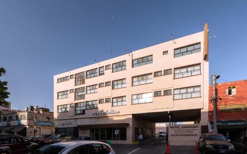 a tall building with cars parked in front of it at Hotel Posada Anahuac in San Luis Potosí