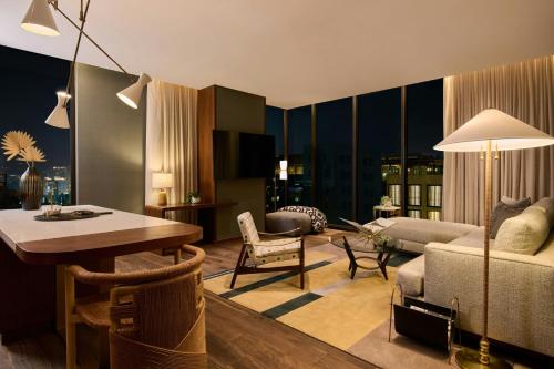 a living room with a couch and a dining room at The Hollywood Grande, Autograph Collection in Los Angeles