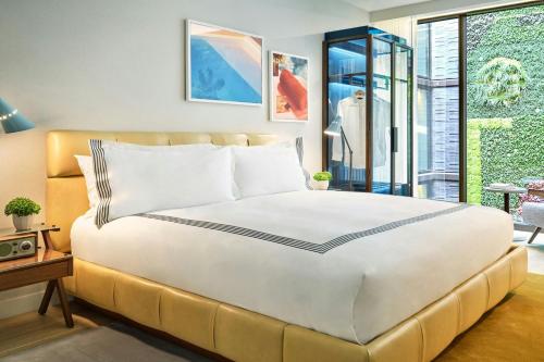 a bedroom with a large bed and a window at The Hollywood Grande, Autograph Collection in Los Angeles