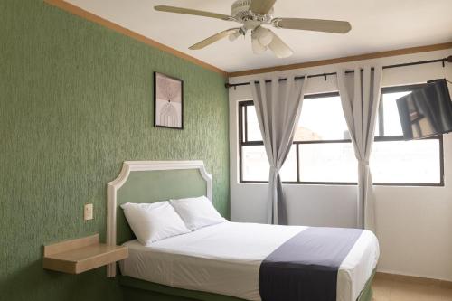 a bedroom with a bed and a ceiling fan at Hotel Posada Anahuac in San Luis Potosí