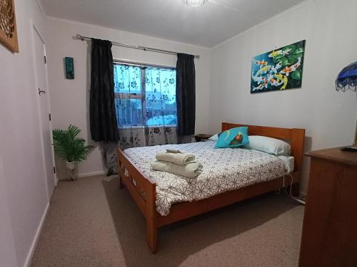 a bedroom with a bed with towels on it at Three Doors Whole 3bdr Home Central Motueka in Motueka