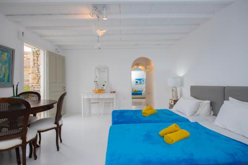 a bedroom with a blue bed with a table and chairs at The Aegean Residence Villa 6 Bedroom nearby the City in Kanalia Area by Hospirit in Mýkonos City