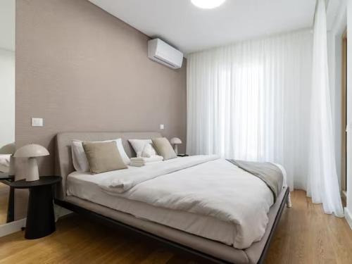a white bedroom with a large bed and a window at Landmark Premium Lux Apartment in Želenička Stanica Beograd Sava