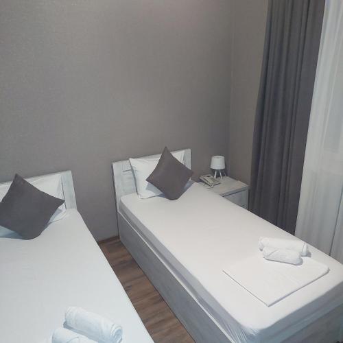 two beds in a small room with a lamp at GARRIOTT TBILISI in Tbilisi City