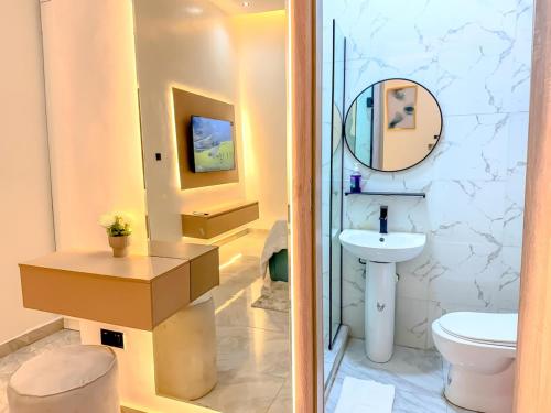 a bathroom with a white toilet and a sink at Sleek & Stylish 2 Bedroom Terrace in Lekki in Maiyegun