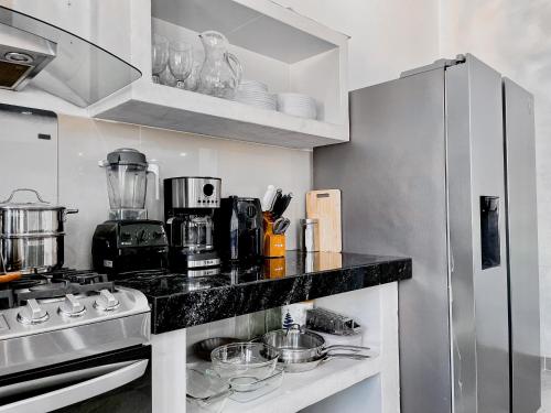 una cocina con encimera y refrigerador en Casa Solaje - Modern Costal house 5 min from Zica, en Puerto Escondido