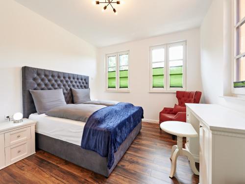 une chambre avec un lit et une chaise rouge dans l'établissement Villa in Wendorf nahe WINSTONgolf Platz, à Müsselmow