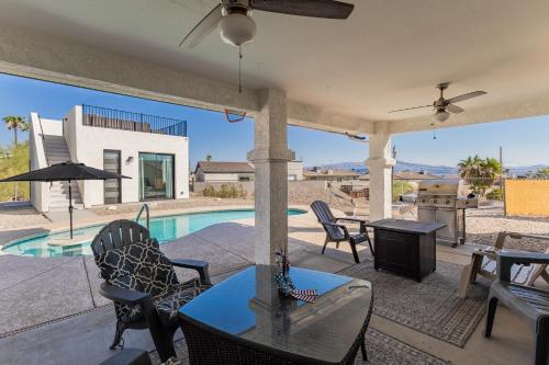 a patio with a table and chairs and a pool at Tranquil Get Away with Lake Views in Lake Havasu City