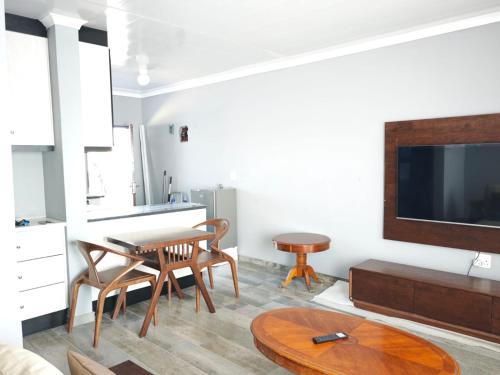 a living room with a table and a tv at The Residence Apartments in Maseru