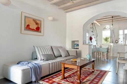 ein Wohnzimmer mit einem weißen Sofa und einem Tisch in der Unterkunft Skaris Guesthouse Tinos in Panormos