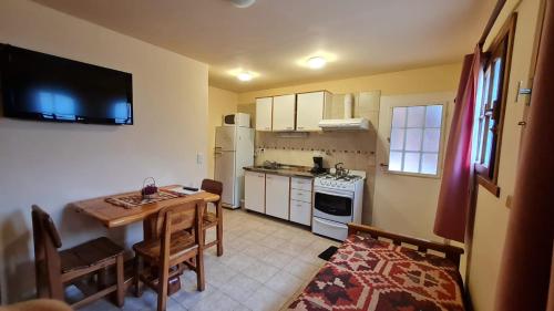 una pequeña cocina con mesa y comedor en Apart Tronador Con Servicios!! Estacionamiento privado, en San Carlos de Bariloche