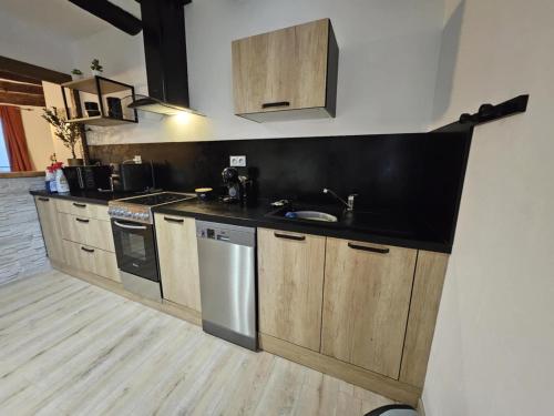 a kitchen with wooden cabinets and a black counter top at La Maison Delle Spellé in Piolenc