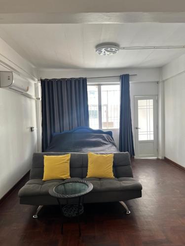 a living room with a couch and a bed at Yok Guesthouse Jomtien in Jomtien Beach