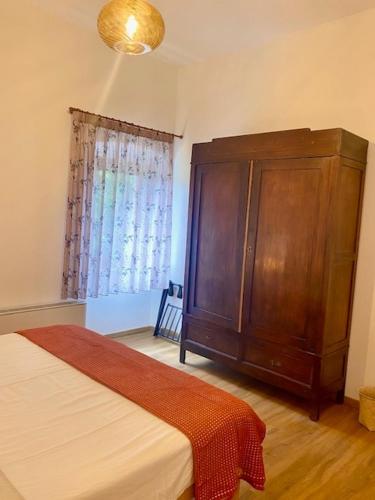 a bedroom with a wooden cabinet and a bed at Podere Ainzara in Montemerano